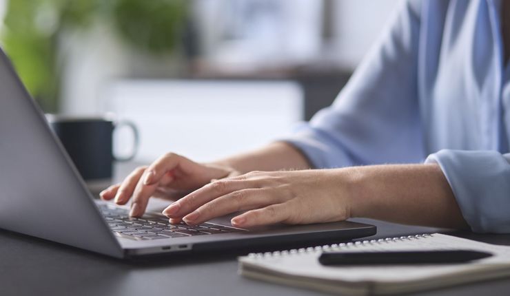 Farbfoto: Frau arbeitet am Laptop