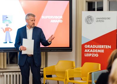 Prof. Kohlmann spricht vor einem Bildschirm