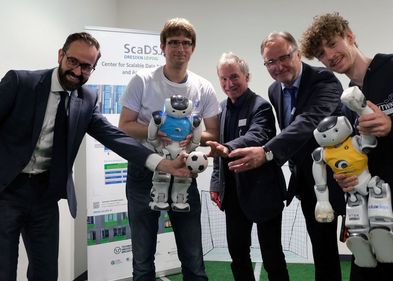 Wissenschaftsminister Sebastian Gemkow, Doktorand Tobias Jagla, Prorektor für Forschung und wissenschaftlichen Nachwuchs Prof. Dr. Erich Schröger, Prof. Dr. Erhard Rahm, wissenschaftlicher Direktor des ScaDS.AI und Felix Loos von HTWK Robots bei der Eröffnungsveranstaltung.