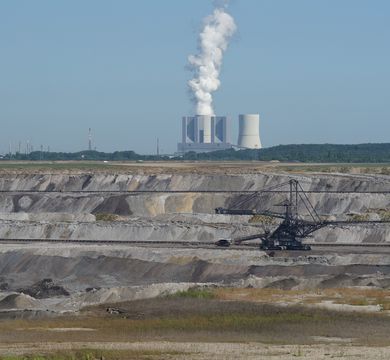 Auf dem Bild ist eine Tagebaulandschaft mit einem Kraftwerk zu sehen.