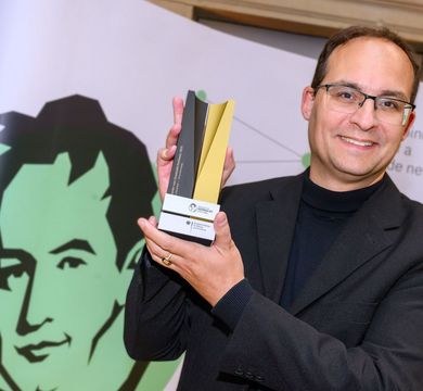Professor Daniel Kráľ mit einer Art Pokal der Humboldt-Stiftung in den Händen.