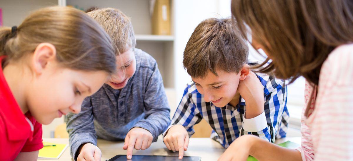 group of school kids with tablet pc computer having fun in classroom